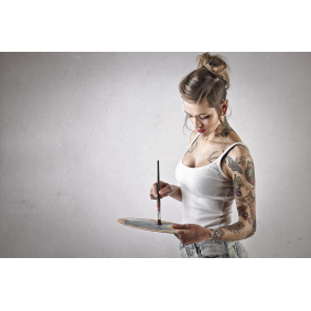 Девушка с татуировками смешивает краски на палитре